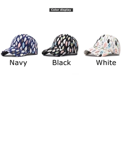 Detailed close-up showing three cotton baseball caps in navy, black, and white with leaf prints