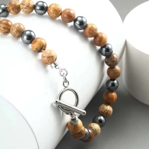 Detailed view of beaded necklace with tiger eye stones and silver metallic OT toggle clasp