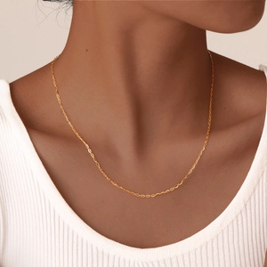 Close-up of minimalist 18K gold plated thin O-chain necklace on model wearing a white top