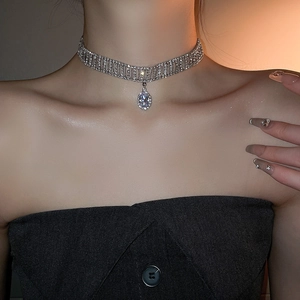 Gros plan d'un choker en strass argenté avec un pendentif goutte d'eau ovale en zircon