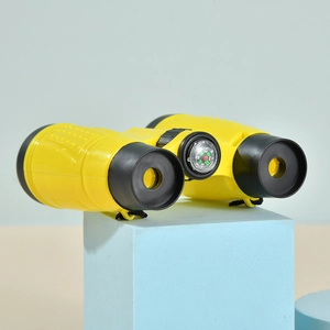 Yellow 6x30 children binoculars with a built-in compass on a blue geometric stand