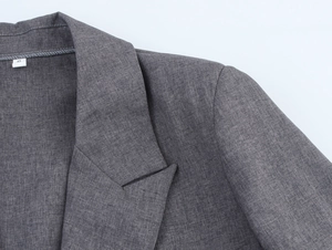 Detailed close-up of grey blazer collar and lapel showing high-quality fabric texture
