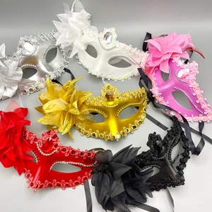 Close-up of masquerade masks with fabric flowers, lace, and sequins in various colors