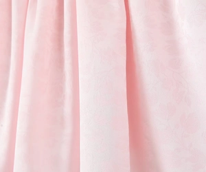 Gros plan détaillé du tissu jacquard rose avec un motif de nœud élégant