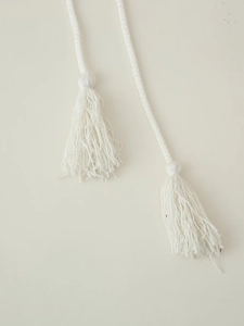 Detailed view of white braided drawstring with fringe tassels for casual cotton linen sets