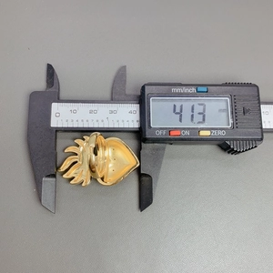 Digital caliper measuring the 41.3 mm width of a gold heart wing adjustable ring