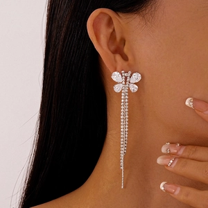Close-up of elegant silver butterfly tassel earrings with sparkling zircon on model
