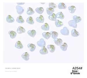 Close-up of 6x6mm heart-shaped aurora crystal nail charms with iridescent finish