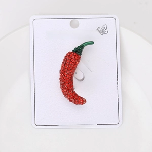 Detailed close-up of a red chili brooch with sparkling red and green rhinestones