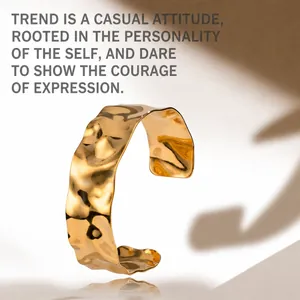 Macro shot of wide gold hammered cuff bracelet with textured finish and sunlight shadows