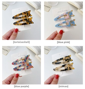 Detail of cat-shaped acetate hair clips with marble patterns in diverse color sets