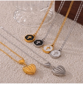 Detail of heart and cross pendant necklaces in gold and silver steel with enamel finish
