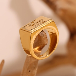 Macro shot of 18K gold plated square ring featuring Never Give Up motivational engraving