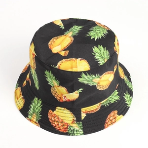 Detailed view of black reversible bucket hat featuring vibrant yellow pineapple prints