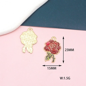 Detail view of a rose-shaped gold alloy charm with red enamel, measuring 15mm by 23mm