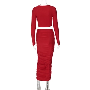 Dettaglio del crop top rosso a maniche lunghe e del set gonna a tubino con pieghe