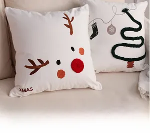 Detailed view of white Christmas pillow covers with reindeer embroidery and Xmas motifs