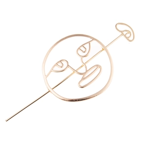 Detail of golden abstract hollow face hairpin with minimalist artistic metal outlines
