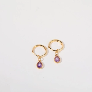 Elegant gold hoop earrings featuring purple teardrop gemstones on a white background