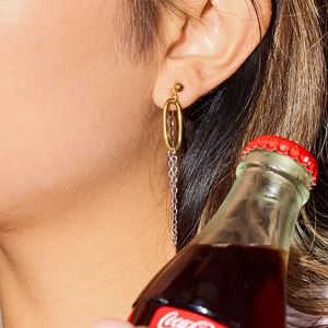 Two-tone gold and silver chain tassel earrings on a model for a modern industrial look