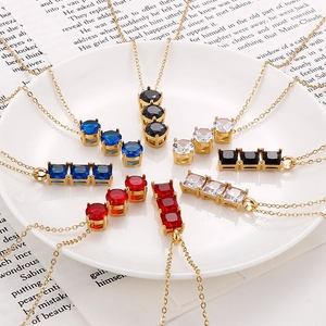 Set di collane in acciaio dorato con zirconi multicolore in un piatto di ceramica