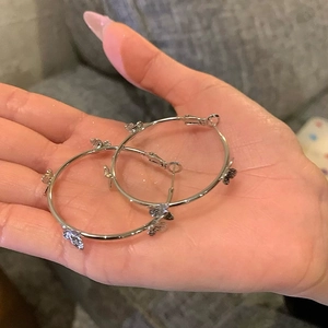 Detail showing silver large hoop earrings featuring delicate hollow butterfly decorations