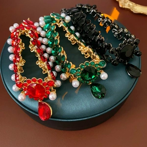 Detailed view of vintage-style pearl necklaces with red, green, and black gemstones