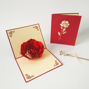Detail showing an elegant 3D pop-up red rose card with a laser-cut floral cover design