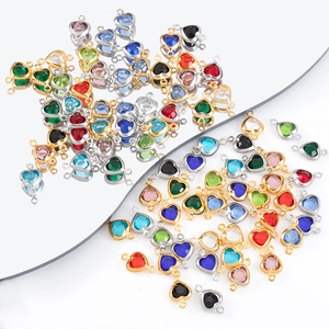 Close-up of colorful heart crystal charms in gold and silver frames for DIY jewelry