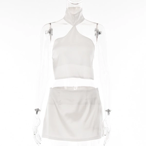 Detail of white satin halter neck top and mini skirt set on a transparent mannequin