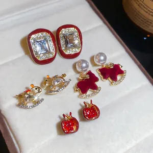Set of four red geometric stud earrings with rhinestones and rocking horse motifs