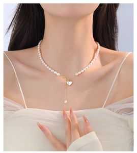 Detail of natural freshwater pearl necklace with heart shell and teardrop pearl pendant