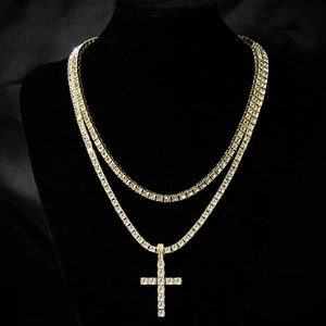 Detail view of gold hip hop tennis chain with cross pendant on black velvet neck model