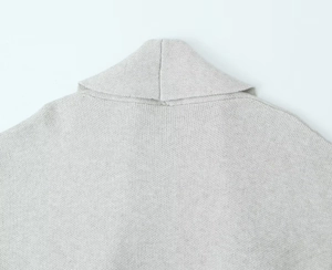 Close-up of the light gray knit cardigan collar and fine shoulder stitching detail