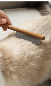 Detailopname van een houten huisdierkam met stalen tanden die lang haar van een dier borstelt