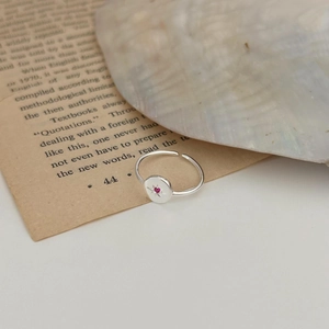Macro detail of 925 sterling silver ring featuring starburst engraving and red gemstone