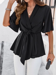 Détail d'un haut noir élégant à col en V avec ceinture nouée et manches mi-longues