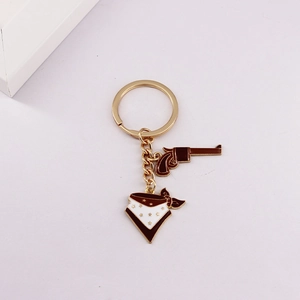 Detail of Western cowboy keychain with brown revolver and enamel triangle scarf charms