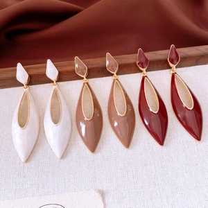 Vue détaillée de trois paires de boucles d'oreilles gouttes en blanc, beige et rouge
