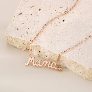 Detail of rose gold Mama pendant necklace with diamond accent on beige stone
