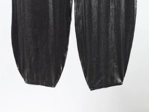 Détail d'une combinaison noire à paillettes avec chevilles élastiquées et éclat métallique