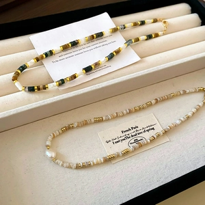 Detail of beaded necklace with green agate, tiger eye stones and freshwater pearls
