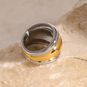 Two-tone chunky ribbed 18k gold plated stainless steel ring on a textured stone base