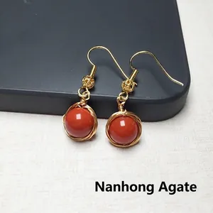 Vue macro de boucles d'oreilles en agate rouge avec fil en or 14K enveloppé à la main