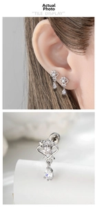 Detail of silver heart crown cartilage earring with sparkling white zircons and teardrop pendant