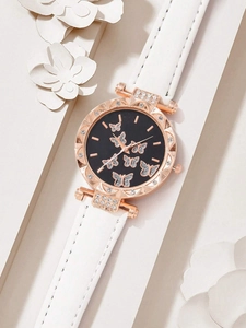 Detail of rose gold watch with butterfly rhinestones on black dial and white leather strap