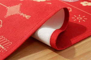 Close-up of red and gold Christmas table runner showing premium linen fabric texture