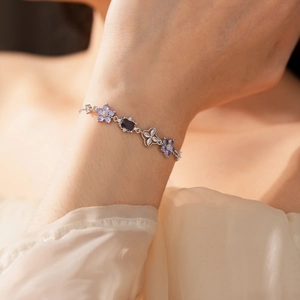 Detail of silver flower bracelet with purple zircon stones on female wrist