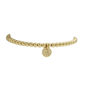 Minimalist golden beaded bracelet featuring a round letter A alphabet charm pendant