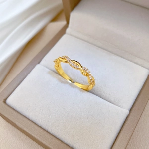 Detailaufnahme des goldenen gedrehten Rings mit winzigen Zirkonsteinen in einer Box